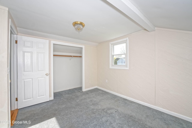unfurnished bedroom featuring a closet, carpet flooring, baseboards, and vaulted ceiling with beams