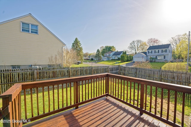 wooden deck featuring a fenced backyard, a yard, and a residential view
