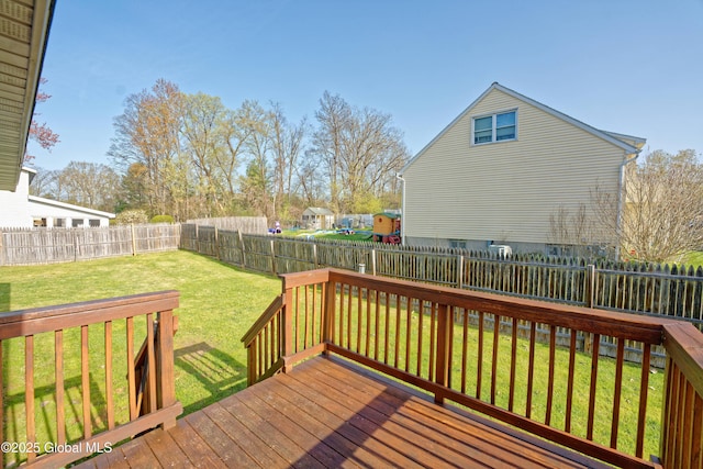 wooden terrace featuring a fenced backyard and a yard