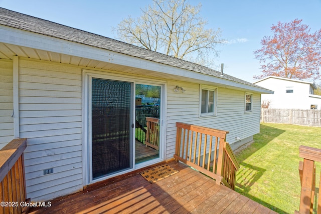 wooden deck featuring a lawn and fence