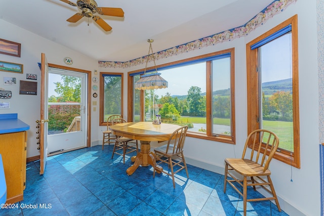 tiled dining space featuring plenty of natural light, baseboards, lofted ceiling, and ceiling fan