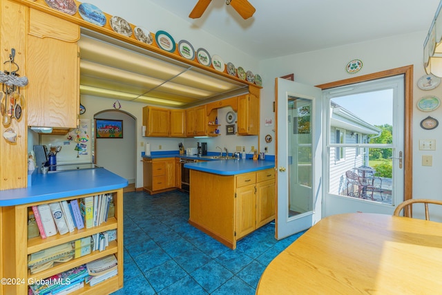 kitchen featuring light countertops, a sink, open shelves, a peninsula, and ceiling fan