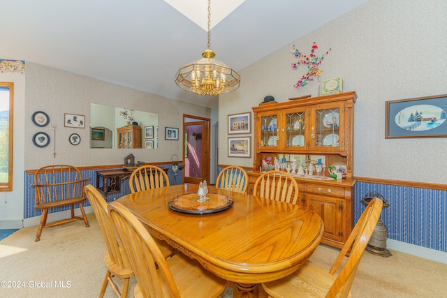 dining room with wallpapered walls, a chandelier, and light carpet