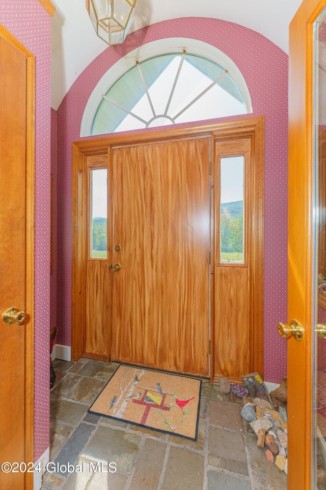 entryway featuring wallpapered walls and stone tile floors
