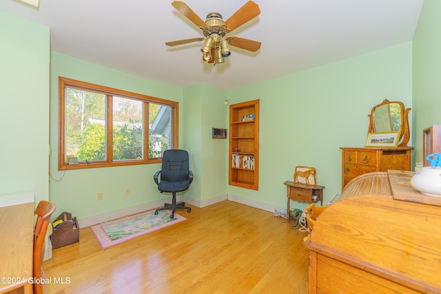 office area with baseboards, light wood-style flooring, and a ceiling fan
