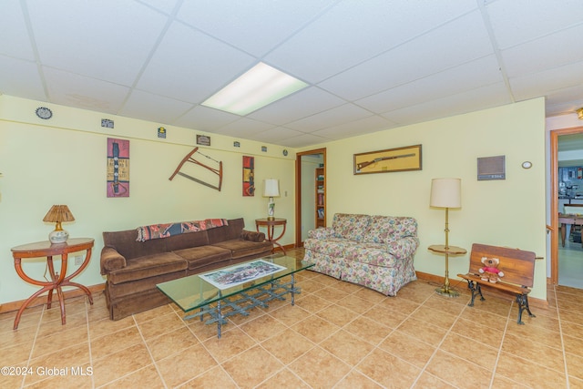 tiled living area featuring baseboards and a paneled ceiling