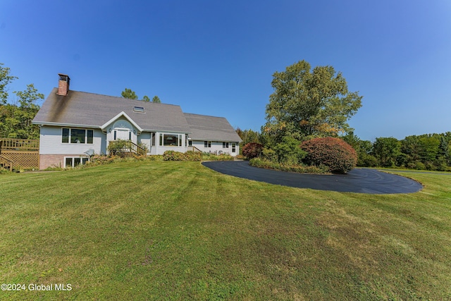 view of front facade with a chimney and a front lawn