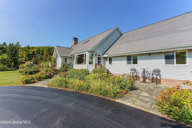 view of front of property featuring a chimney and a patio area