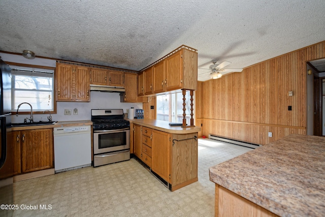200 Summit Lake Rd, Argyle, NY 12809 - kitchen with a peninsula, gas range, baseboard heating, white dishwasher, and under cabinet range hood