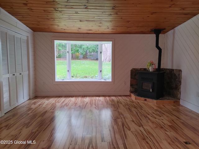 6 Father Jogues Pl, Ticonderoga, NY 12883 - unfurnished living room featuring wooden ceiling, lofted ceiling, light wood finished floors, a wood stove, and wood walls