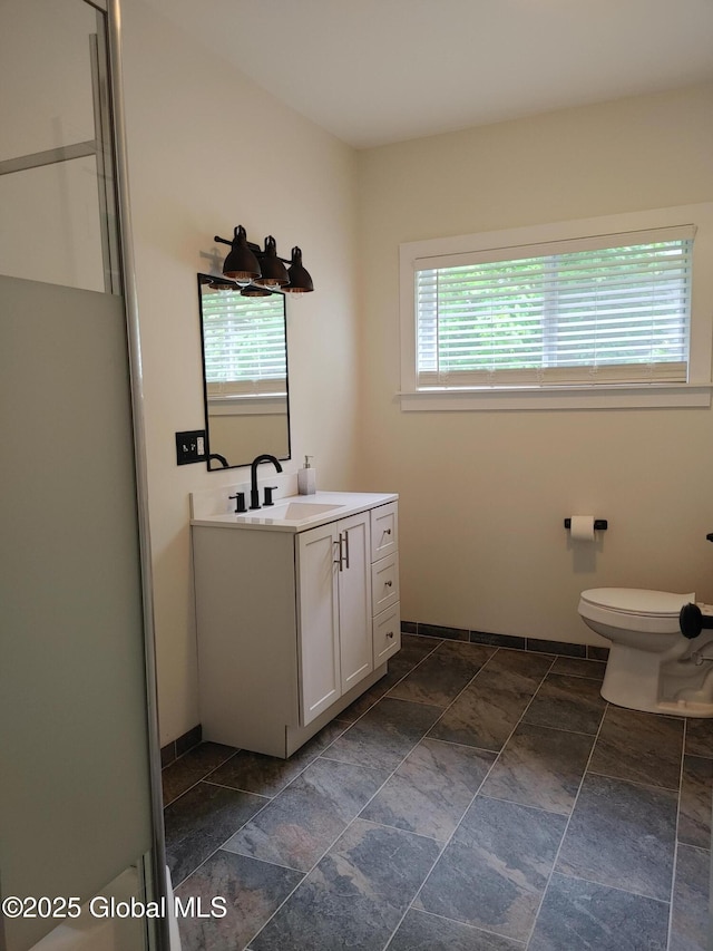 6 Father Jogues Pl, Ticonderoga, NY 12883 - bathroom with stone finish flooring, vanity, toilet, and baseboards