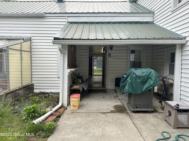 doorway to property with metal roof and a patio