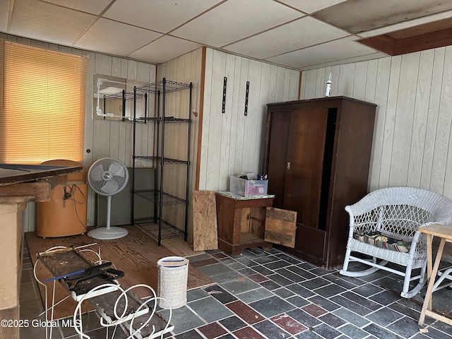 bathroom with wood walls and a drop ceiling