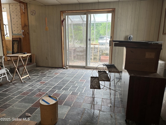 living room featuring wooden walls and brick floors