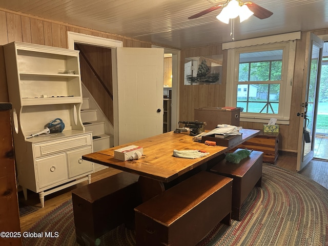 office space with wooden walls, dark wood finished floors, and ceiling fan