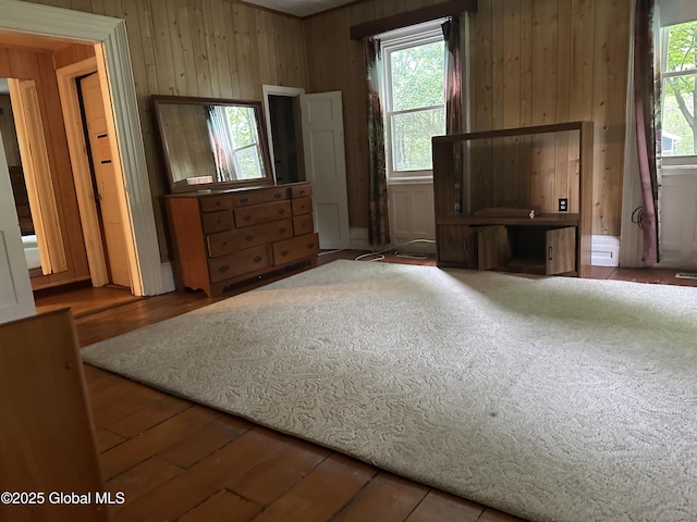 unfurnished bedroom with wood walls and hardwood / wood-style floors