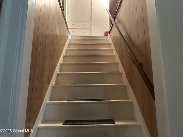 stairs featuring wooden walls