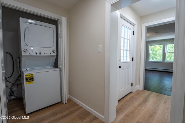 65 N Main St, Voorheesville, NY 12186 - laundry room featuring estacked washer and dryer, a baseboard heating unit, and light wood-style floors