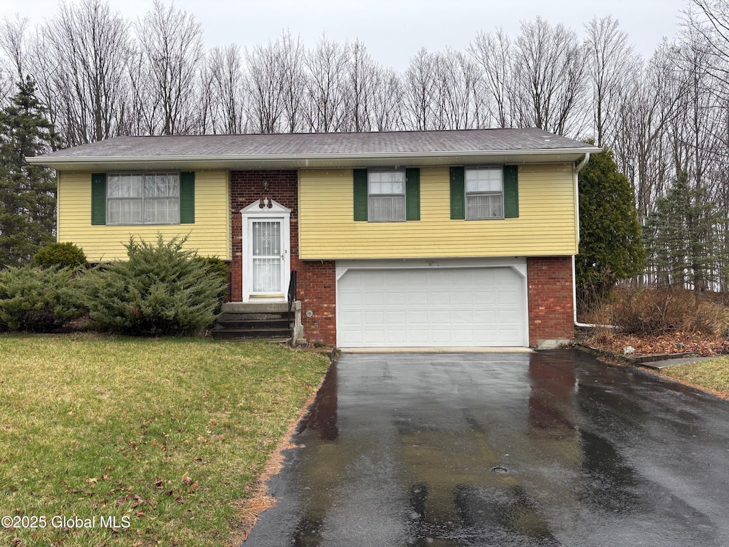 112 Springhollow Dr, Cohoes, NY 12047 - raised ranch featuring driveway, an attached garage, brick siding, and a front yard