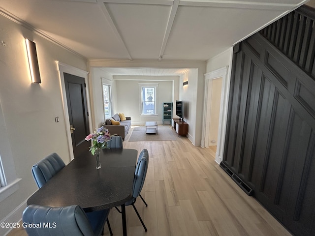 dining space with baseboards and light wood-style flooring