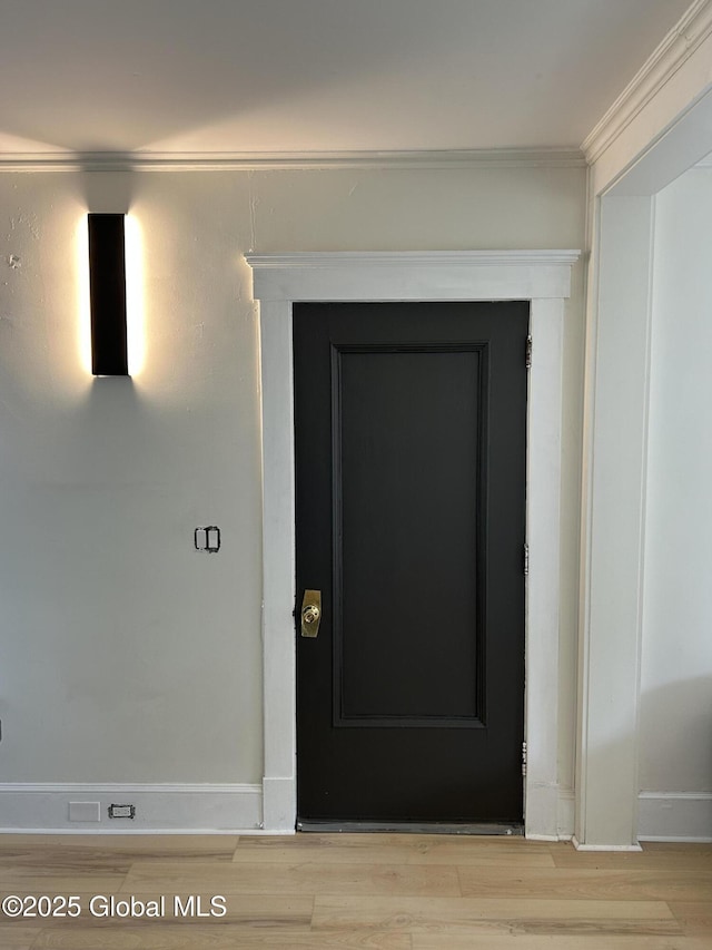 interior details featuring baseboards, crown molding, and wood finished floors