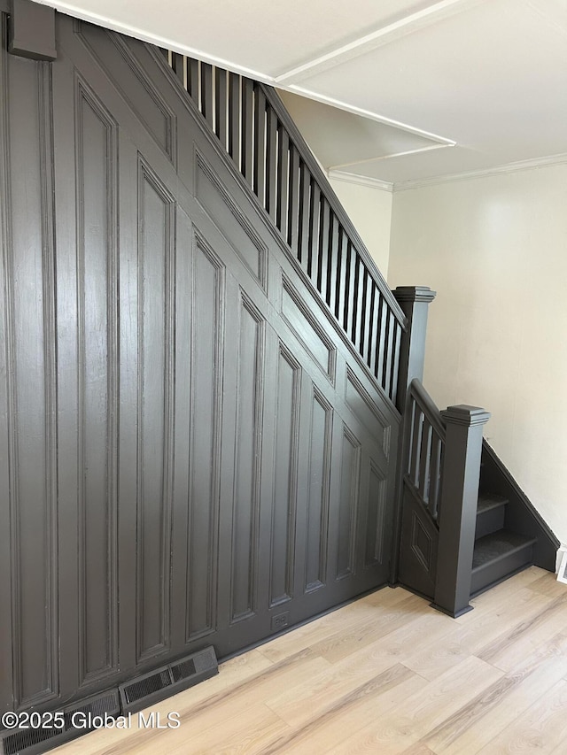 stairs featuring attic access, visible vents, and wood finished floors