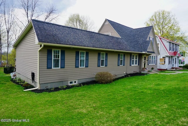 back of house featuring a yard and a shingled roof