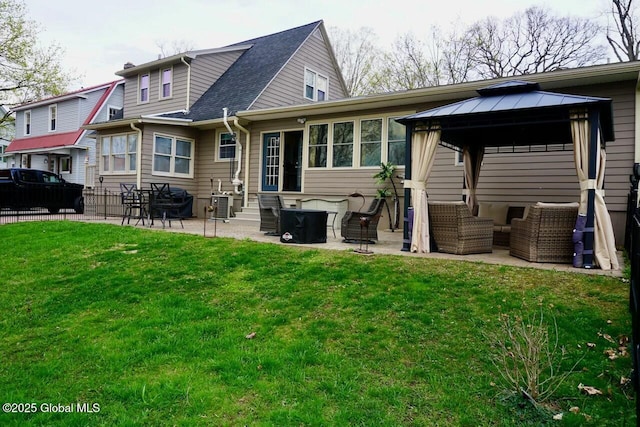 rear view of property with a yard, fence, a gazebo, a patio, and an outdoor hangout area