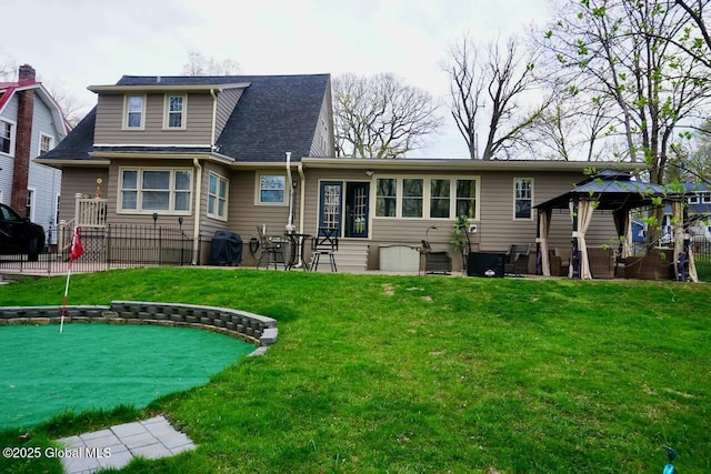back of house featuring fence, a gazebo, and a lawn