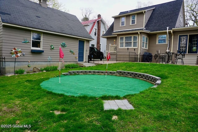 rear view of house featuring fence and a yard