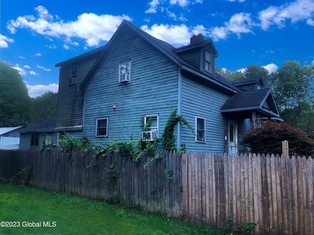 view of home's exterior featuring fence and a chimney