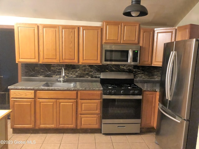 kitchen with backsplash, stainless steel appliances, light tile patterned floors, and a sink
