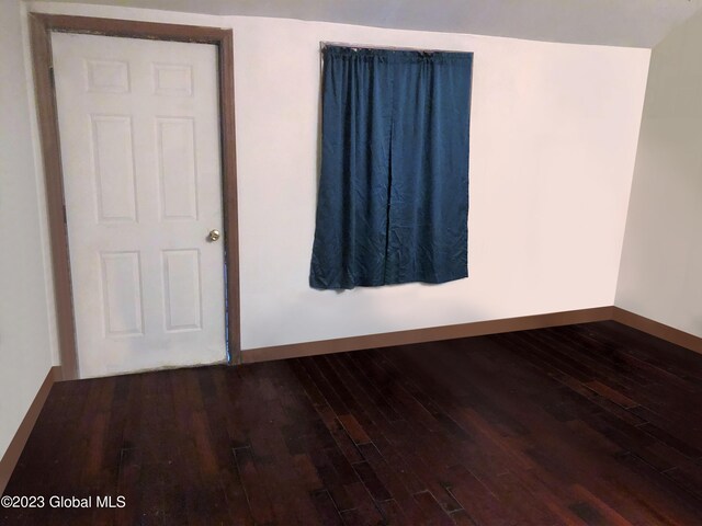 empty room featuring baseboards and hardwood / wood-style floors