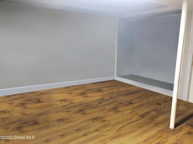 empty room featuring baseboards and wood finished floors
