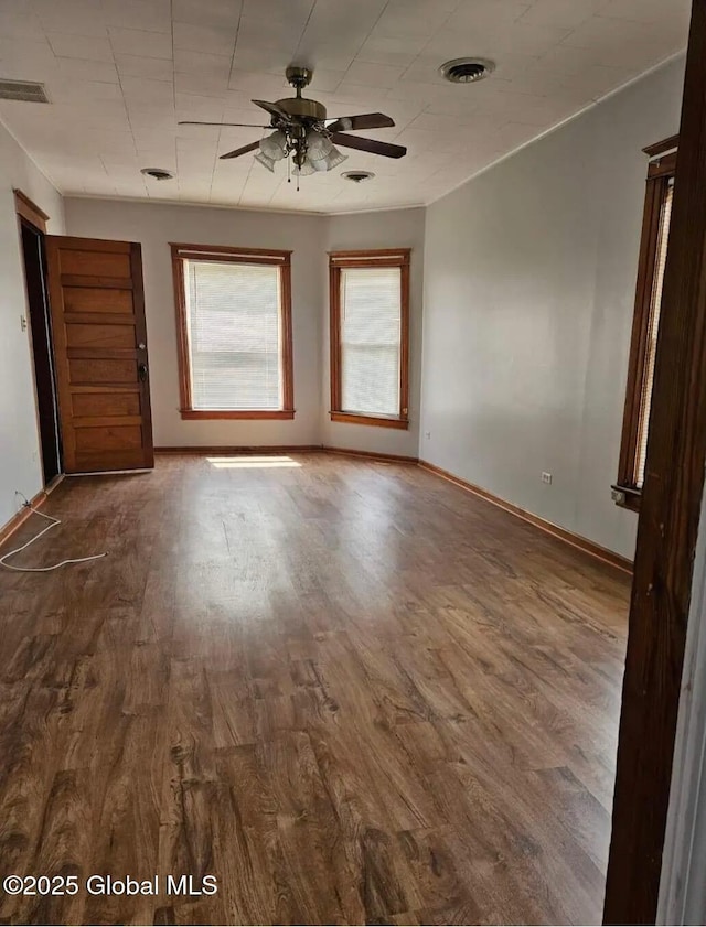 unfurnished room with visible vents, baseboards, a ceiling fan, and wood finished floors