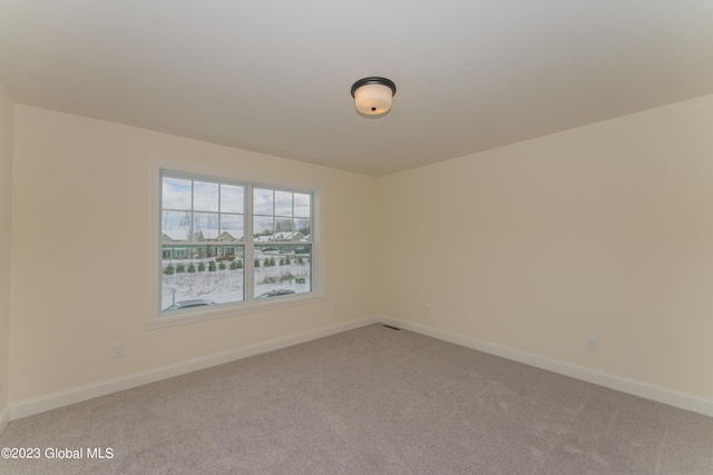 empty room with light carpet and baseboards