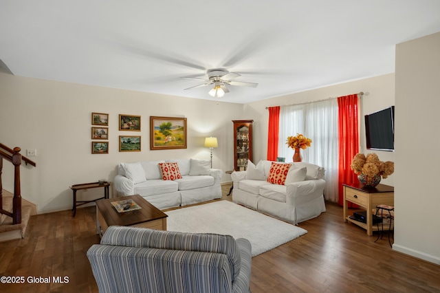 living room featuring stairway, ceiling fan, baseboards, and wood finished floors