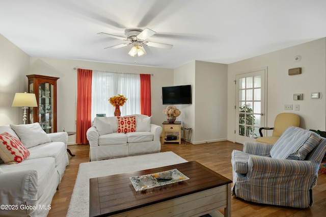 living room featuring a wealth of natural light, a ceiling fan, and wood finished floors