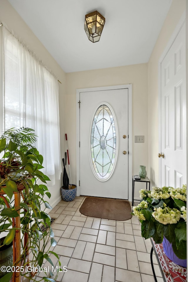foyer entrance featuring baseboards and light tile patterned floors