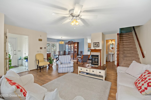 living area featuring light wood-style flooring, stairway, and ceiling fan