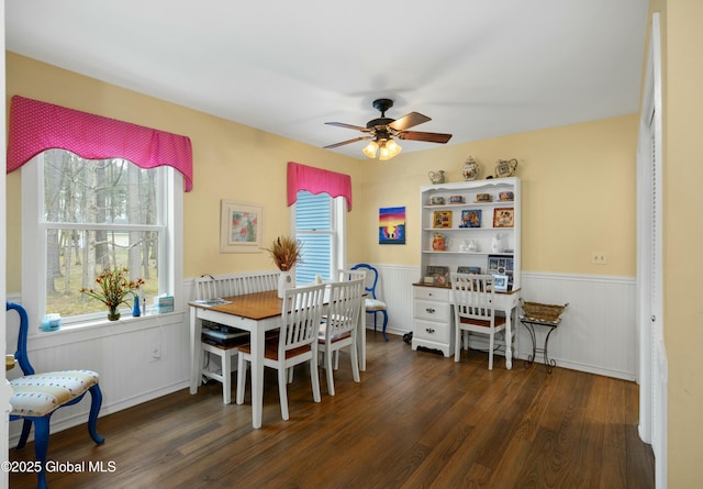 dining room with wainscoting, a ceiling fan, and wood finished floors