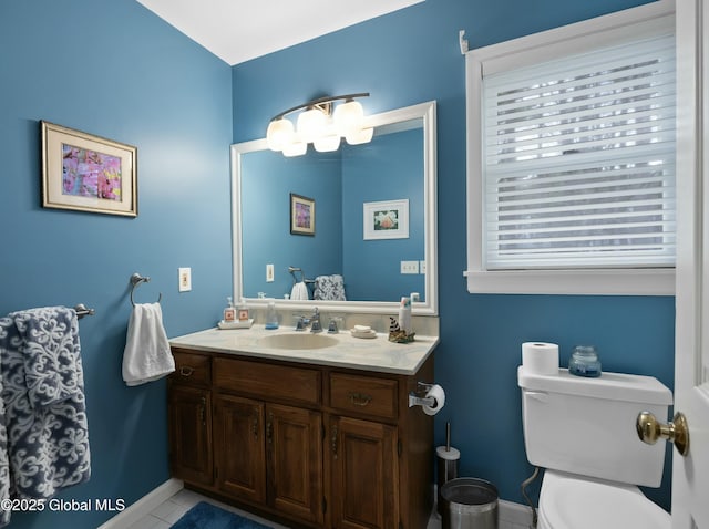 bathroom featuring vanity, tile patterned floors, baseboards, and toilet