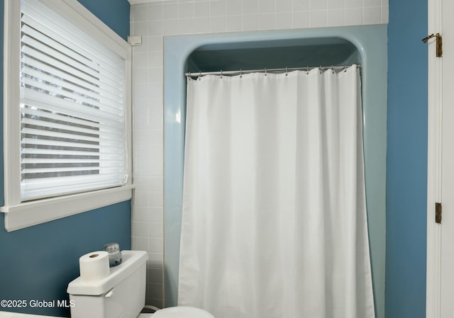 full bath with curtained shower and toilet