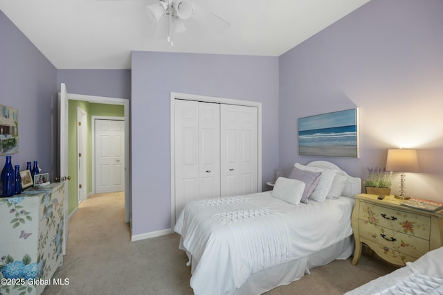 bedroom featuring light carpet, vaulted ceiling, baseboards, a ceiling fan, and a closet