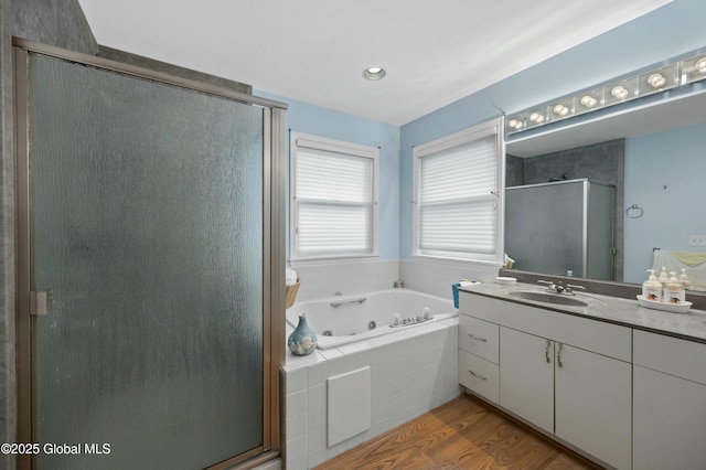full bathroom with vanity, wood finished floors, a shower stall, and a tub with jets