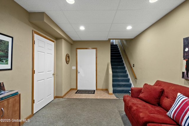 tiled living room with recessed lighting, a paneled ceiling, carpet floors, and stairs