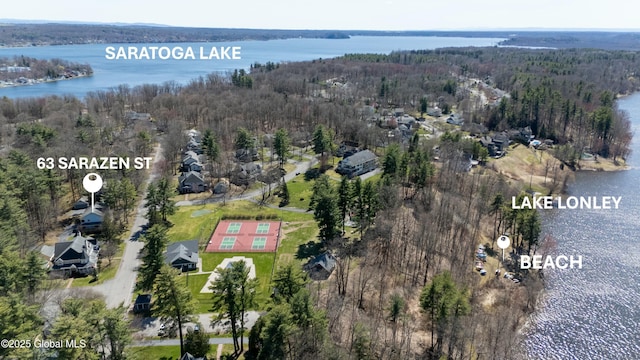 birds eye view of property featuring a forest view and a water view
