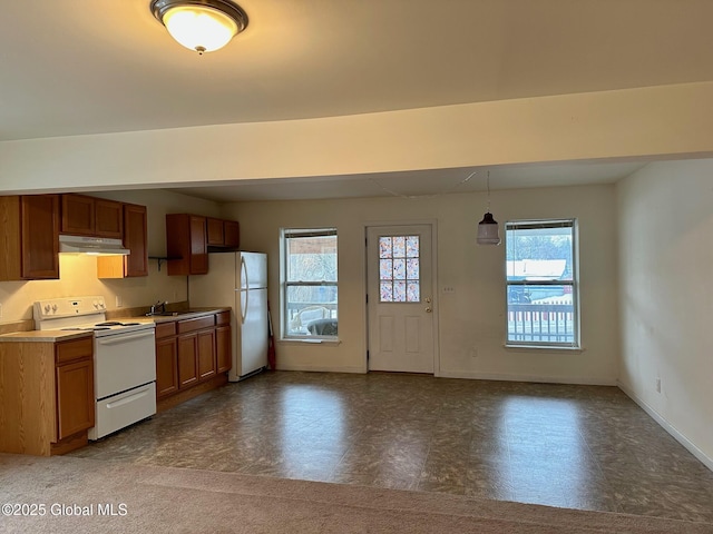 kitchen featuring baseboards, white appliances, under cabinet range hood, brown cabinets, and a sink