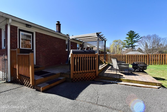 wooden deck featuring a pergola, fence, and a fire pit
