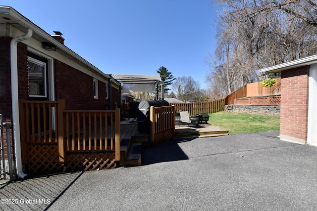 view of patio with fence and a deck